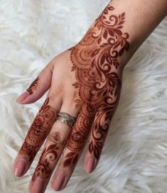 a woman's hand with henna tattoos on it