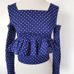 Unique ,pretty polka dot top has a button fastening at back with long narrow sleeves that flare out at cuffs. The sleeves are set with bare shoulders. It is close fitting, with peplum skirt that sits just under the bust and is a short cropped style. This top is XS , fitting someone of UK size 6 /8. Bust of 30/31  inches (80 cm ), waist of 24/26 inches,61 cm ) Long Sleeve Polka Dot Blouse For Summer, Fitted Polka Dot Top For Spring, Fitted Long Sleeve Peplum Top For Summer, Polka Dot Long Sleeve Tops For Party, Spring Long Sleeve Peplum Top For Party, Fitted Long Sleeve Peplum Top For Party, Chic Fitted Long Sleeve Peplum Top, Fitted Long Sleeve Polka Dot Blouse, Polka Dot Long Sleeve Party Tops