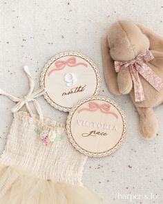 a teddy bear and two tags with the names of each child's name on them