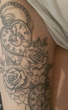 a woman's thigh with roses and clocks on it