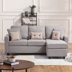 a living room with a gray couch and pillows on the floor next to a coffee table