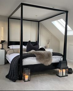 an image of a bedroom setting with four poster bed and candles on the nightstands