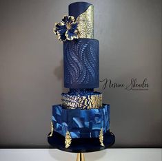 a three tiered blue and gold wedding cake