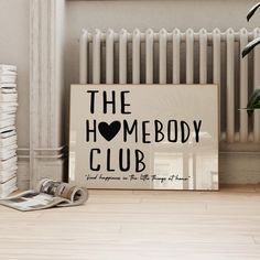 a sign that says the homeboy club next to a stack of newspapers and a potted plant