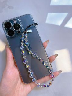 a woman's hand holding an iphone case with a chain attached to it