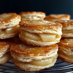 a pile of pancakes sitting on top of a metal rack filled with syrup covered pastry