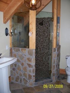 a bathroom with a stone shower and sink