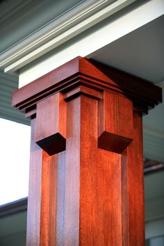 the top of a wooden clock tower in front of a window