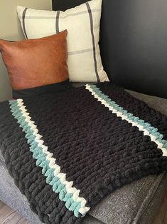 a bed with a blanket and two pillows on top of it next to a pillow