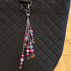 a black purse with pink and green beads hanging from it