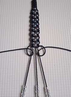 a close up of a black string with beads on it and two strings attached to each other