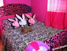 a dog laying on top of a bed in a room with pink walls and leopard print