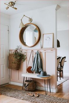 a room with a bench, mirror and coat rack