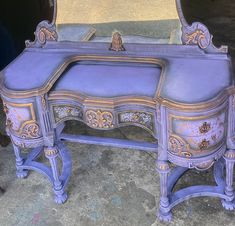 an old purple vanity with mirror on top