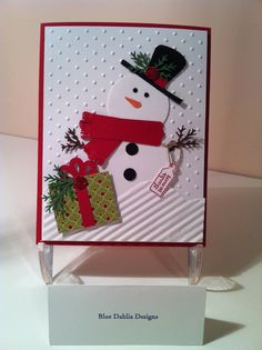 a christmas card with a snowman wearing a hat and scarf