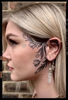 a woman with tattoos on her face and ear