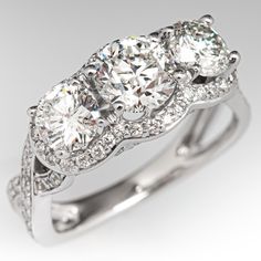 three stone engagement ring with diamond accents on the band and sidestones in 18k white gold