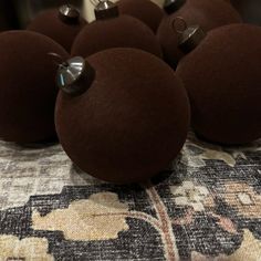 several brown balls are sitting on a table with some silver pins sticking out of them