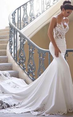 a woman in a wedding dress is standing on the stairs with her hand on her hip