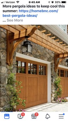 two wooden garage doors are open on the side of a stone building with flowers in front