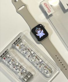 an apple watch with hello kitty stickers on it and its packaging next to it