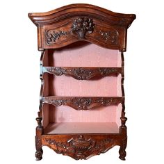 an old wooden shelf with pink fabric on the bottom and two shelves below it,