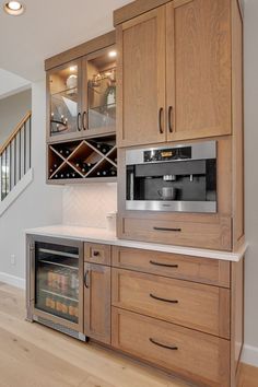 a kitchen with wooden cabinets and a wine rack in the corner, along with a built - in oven