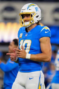 a close up of a football player wearing a helmet and holding his hand out to the side