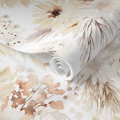 a floral wallpaper with brown and white flowers on it's side, next to a roll of toilet paper