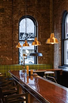 an empty bar with two lamps hanging from the ceiling