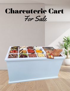 a white counter topped with lots of different types of food on top of wooden floors