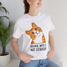 a woman wearing an orange white and not so bright t - shirt with a cat on it