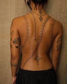 the back of a woman with tattoos on her body