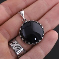 This sterling silver handmade pendant necklace features a stunning black onyx gemstone. The onyx adds a touch of elegance and sophistication to the necklace, making it the perfect accessory for any occasion. The pendant hangs from a sterling silver chain, which adds a touch of shine and sparkle to the necklace. The necklace is perfect for anyone looking for a stylish, timeless piece of jewelry that can be dressed up or down. Are you looking for a truly unique and special piece of jewelry? Look no further than handmade necklaces! Our Handmade necklaces are crafted by skilled artisans who put their time, passion, and creativity into each piece they make. Unlike mass-produced necklaces, handmade necklaces are one-of-a-kind and have a certain character and charm that cannot be replicated. Each Silver Obsidian Pendant Necklace, Round Obsidian Jewelry For Gift, Obsidian Round Jewelry For Gift, Obsidian Round Jewelry Gift, Formal Black Necklaces With Natural Stones, Black Agate Gemstone Necklace, Silver Obsidian Gemstone Necklace, Black Agate Jewelry For Gifts, Black Necklaces With Natural Stones