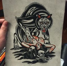 someone holding up a piece of paper with an image of a wolf and skull on it