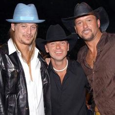 three men in cowboy hats posing for the camera at an event with one man wearing a leather jacket