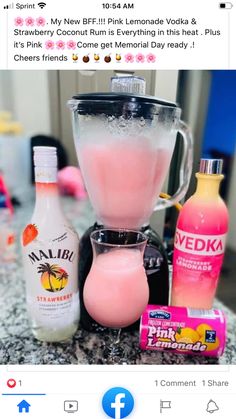 a blender filled with pink liquid next to other items on top of a counter