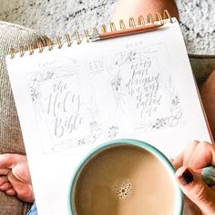 a woman holding a cup of coffee while sitting on the floor next to a notebook