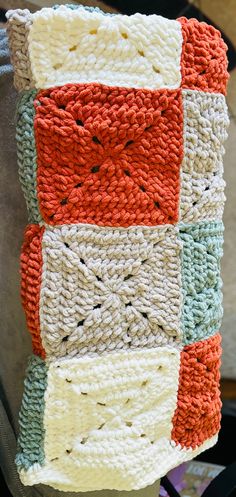 a crocheted dishcloth hanging from a hook on a chair in front of a window