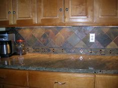 a kitchen with wooden cabinets and tile backsplash inlays on the counter