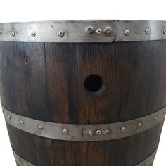 a wooden barrel with metal rivets on the bottom and sides, isolated against a white background