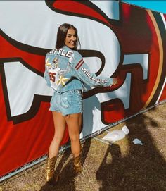 a woman standing in front of a giant sign and posing for the camera with her hands on her hips