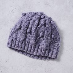 Purple Flowers Cable Knit Hat | Timeless cable knit with a pretty purple twist! This soft, hand knit winter hat will keep your head and ears toasty during outdoor adventures. Vine and cable knit details add interest and texture to a classic and st... Knit Winter Hat, Chain Scarf, Candle Wall Decor, Cable Knit Hat, Pretty Purple, Scarf Hat, Accessories Bags Purses, Cold Weather Accessories, Winter Knits