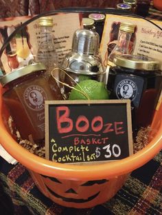 a halloween basket with booze and cocktails for $ 30 on the table in front of a sign