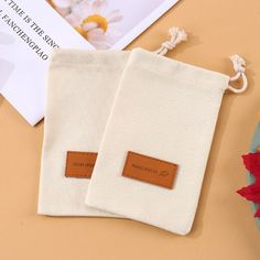 two pieces of white cloth with brown leather tags