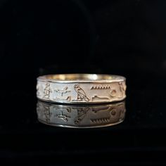 Crafted with meticulous attention to detail, this ring boasts a design adorned with captivating hieroglyphics that whisper tales of mystique and power. At its core lies a profound message, engraved in the ancient language of the pharaohs: "I am one of those shining beings of light." These words, laden with significance, echo the timeless quest for enlightenment and the divine within. The sleek and polished surface of the ring serves as the perfect canvas for the intricate hieroglyphics. Look clo Symbolic Formal Jewelry With Etched Details, Formal Symbolic Etched Jewelry, Symbolic Etched Jewelry For Ceremonial Occasions, Symbolic Ceremonial Etched Jewelry, Ceremonial Symbolic Etched Jewelry, Antique Etched Rings For Ceremonial Occasions, Ceremonial 14k Gold Engraved Intaglio Ring, Symbolic Engraved Ring With Intricate Design, Symbolic Ceremonial Jewelry With Engraving Option