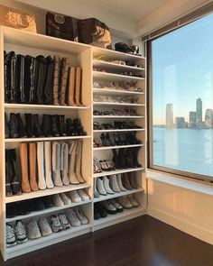 a closet with many pairs of shoes on shelves next to a window overlooking the water