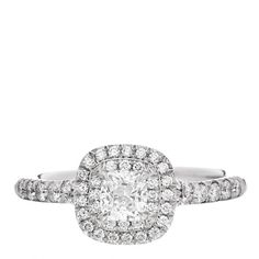 a cushion cut diamond ring with pave set diamonds on the shoulders and sides, in white gold