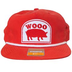 a red hat with the word woo on it and a pig patch in front of it