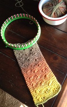 a crocheted tie sitting on top of a wooden table next to a cup